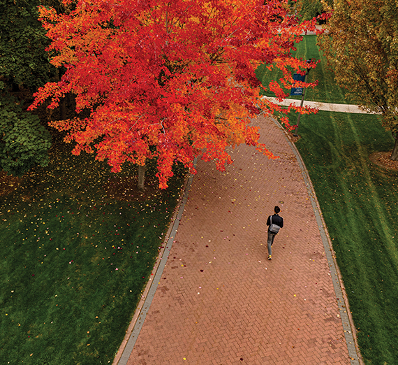 Una mujer sentada en un taburete junto a un podio