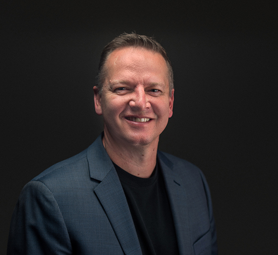 Una mujer sentada en un taburete junto a un podio